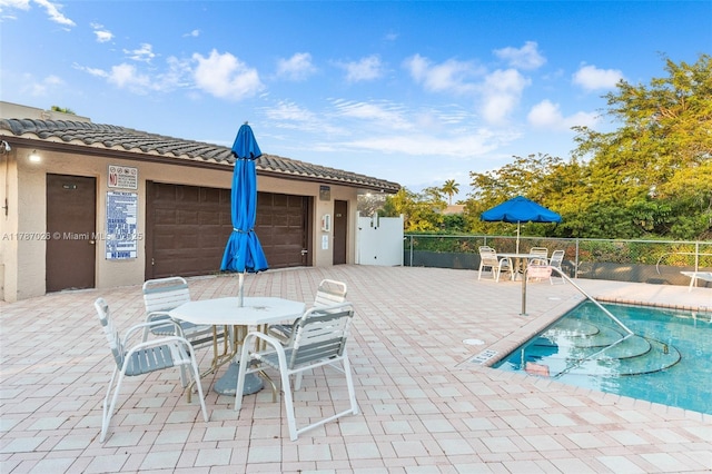 3111 Coral Springs Dr Unit 211, Coral Springs, FL 33065 - view of patio / terrace with outdoor dining space, a community pool, and a garage