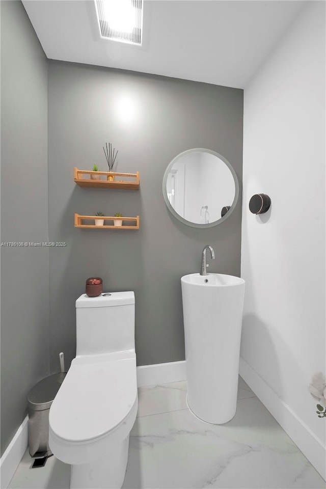 10700 NW 66th St Unit 103, Doral, FL 33178 - bathroom with baseboards, marble look tiles, and toilet