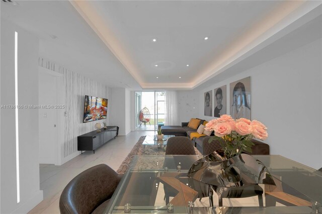 10700 NW 66th St Unit 103, Doral, FL 33178 - living area featuring light marble finish flooring, a tray ceiling, recessed lighting, and baseboards