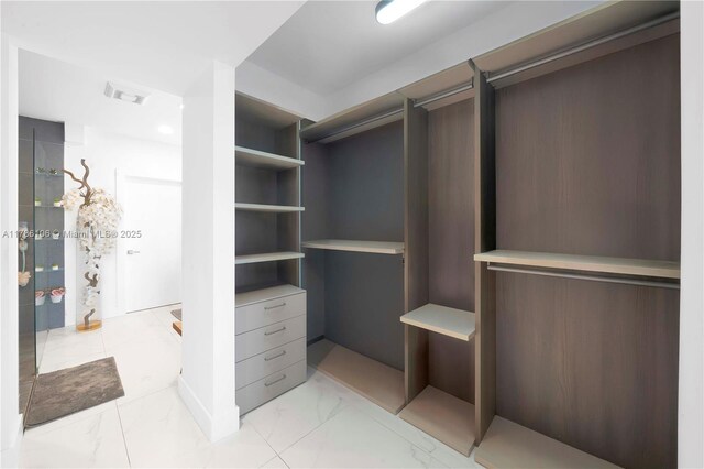 10700 NW 66th St Unit 103, Doral, FL 33178 - walk in closet featuring light marble finish flooring