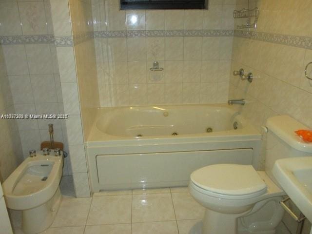 full bath featuring tile walls, tile patterned floors, a bidet, and toilet