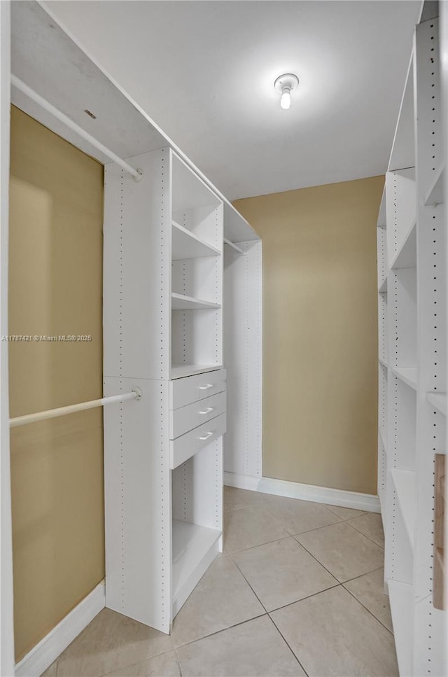 walk in closet with light tile patterned floors