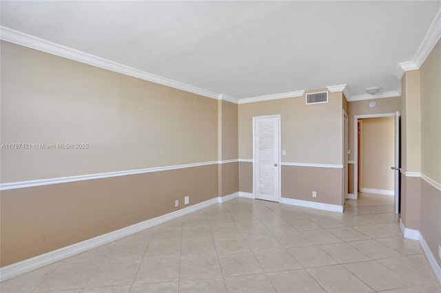 empty room featuring baseboards, visible vents, ornamental molding, and light tile patterned flooring