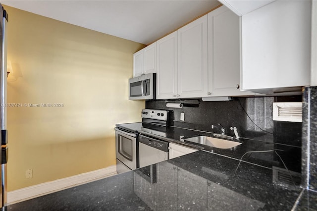 1455 N Treasure Dr Unit 7F, North Bay Village, FL 33141 - kitchen with stainless steel appliances, decorative backsplash, white cabinets, and dark stone counters