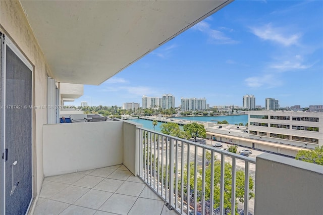balcony with a water view and a view of city