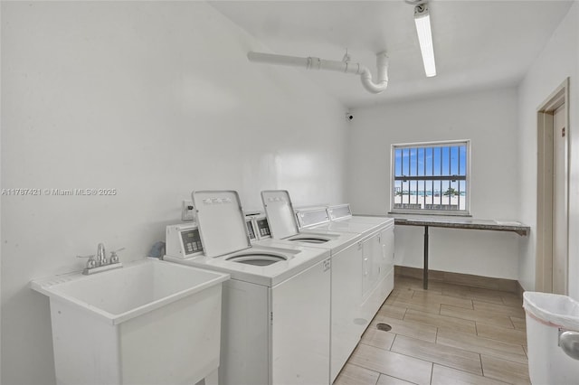 shared laundry area featuring washer and dryer and a sink
