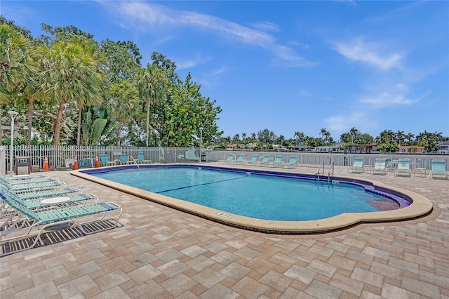 pool with a patio and fence