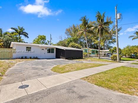 1310 NW 41st St, Oakland Park, FL 33309 - manufactured / mobile home featuring fence, driveway, and a front lawn