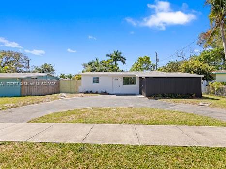 1310 NW 41st St, Oakland Park, FL 33309 - single story home with fence, driveway, and a front lawn