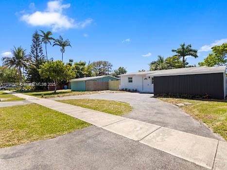 1310 NW 41st St, Oakland Park, FL 33309 - view of front of home featuring a front yard and aphalt driveway