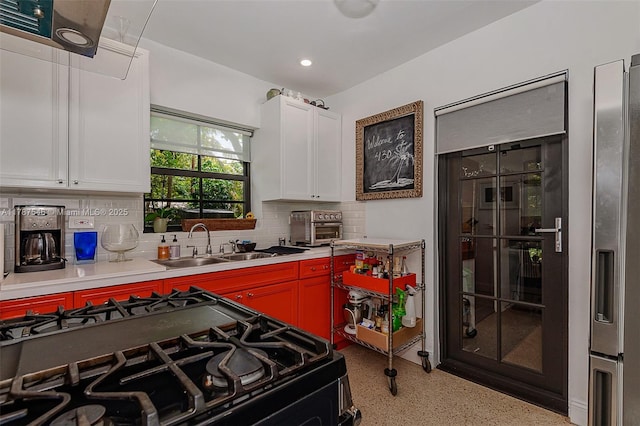 430 NE 132nd Ter, North Miami, FL 33161 - kitchen featuring white cabinets, light countertops, a sink, gas stove, and decorative backsplash