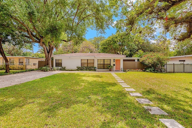 430 NE 132nd Ter, North Miami, FL 33161 - view of front of property featuring stucco siding, fence, and a front yard
