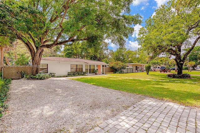 430 NE 132nd Ter, North Miami, FL 33161 - exterior space with a lawn, driveway, a tiled roof, fence, and stucco siding
