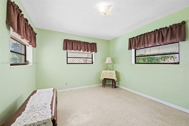 sitting room with speckled floor, a textured ceiling, and baseboards