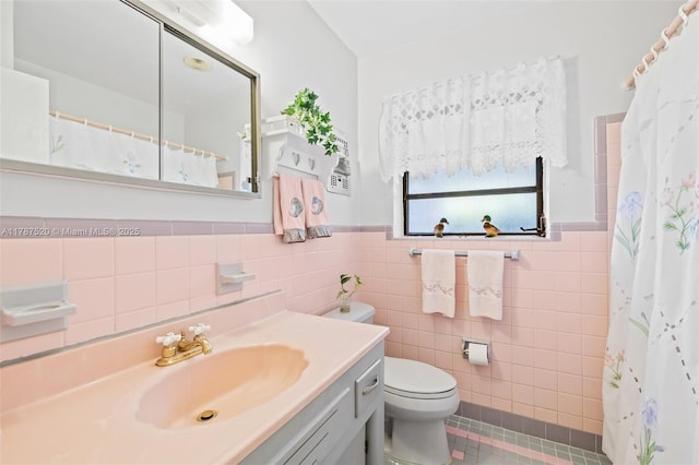 full bath with tile walls, toilet, vanity, and wainscoting