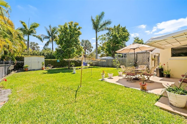 view of yard with a patio area, a fenced backyard, an outbuilding, and a storage shed