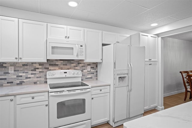 kitchen featuring backsplash, light wood finished floors, white cabinetry, and white appliances