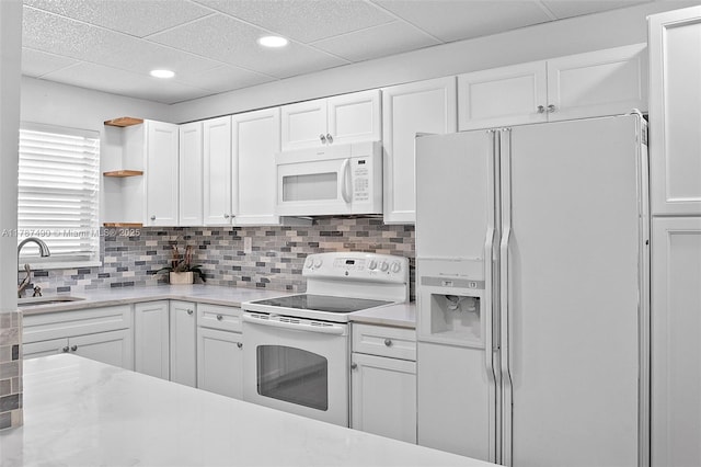 kitchen featuring open shelves, light countertops, a sink, white appliances, and white cabinetry