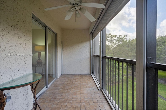 unfurnished sunroom featuring a ceiling fan