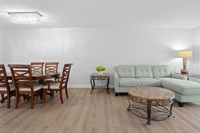 dining area featuring light wood-style floors and a textured ceiling