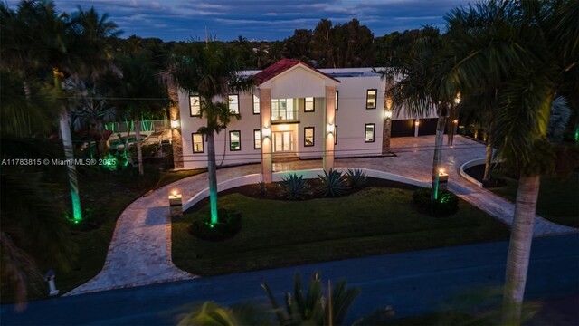 1430 NW 114th Ave, Plantation, FL 33323 - view of front of house featuring stucco siding, curved driveway, a front yard, a balcony, and french doors