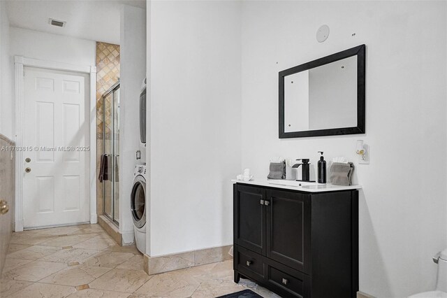 1430 NW 114th Ave, Plantation, FL 33323 - full bathroom featuring estacked washer and dryer, a stall shower, stone tile floors, and baseboards