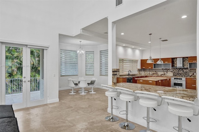 1430 NW 114th Ave, Plantation, FL 33323 - kitchen featuring brown cabinets, oven, baseboards, decorative backsplash, and french doors