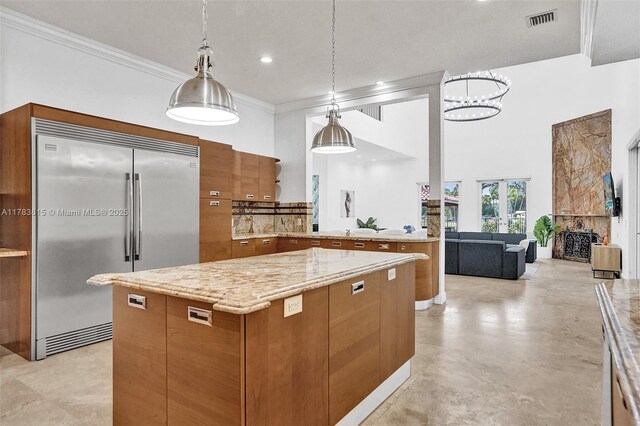 1430 NW 114th Ave, Plantation, FL 33323 - kitchen with stainless steel built in fridge, brown cabinetry, a center island, light stone counters, and hanging light fixtures