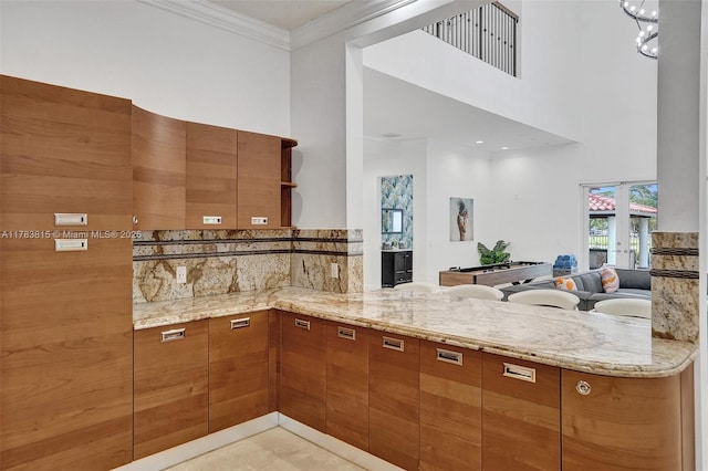 1430 NW 114th Ave, Plantation, FL 33323 - kitchen with brown cabinetry, light stone countertops, a peninsula, backsplash, and ornamental molding