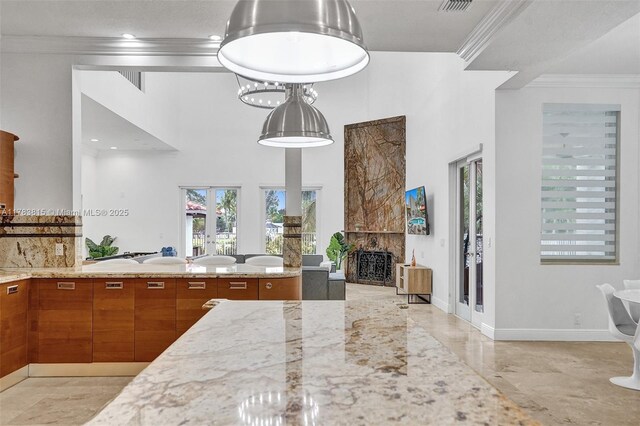1430 NW 114th Ave, Plantation, FL 33323 - kitchen featuring brown cabinetry, crown molding, light stone counters, a fireplace, and decorative backsplash