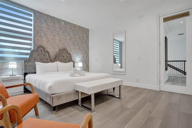 1430 NW 114th Ave, Plantation, FL 33323 - bedroom with wallpapered walls, light wood-style flooring, multiple windows, baseboards, and an accent wall
