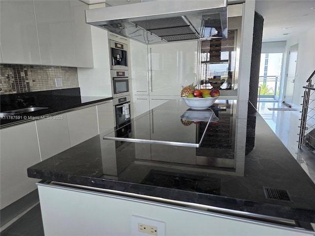 2950 NE 188th St Unit 501, Aventura, FL 33180 - kitchen featuring ventilation hood, white cabinetry, modern cabinets, tasteful backsplash, and a sink