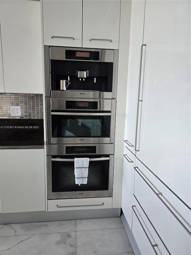 2950 NE 188th St Unit 501, Aventura, FL 33180 - kitchen featuring paneled built in fridge, white cabinetry, double oven, and modern cabinets