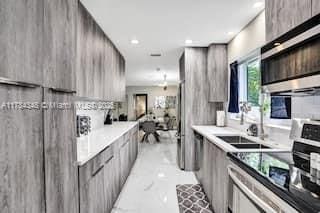 1321 S 16th Ave, Hollywood, FL 33020 - kitchen featuring stove, stainless steel microwave, modern cabinets, gray cabinets, and recessed lighting