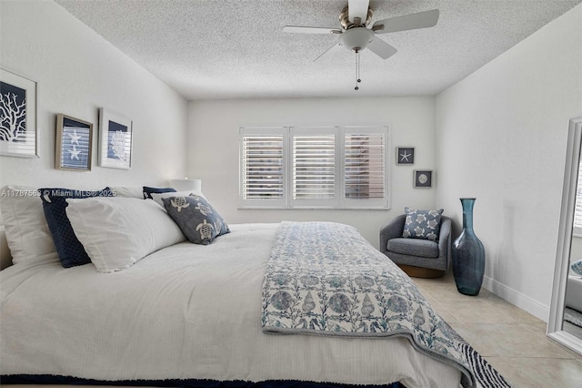tiled bedroom featuring a textured ceiling, a ceiling fan, and baseboards