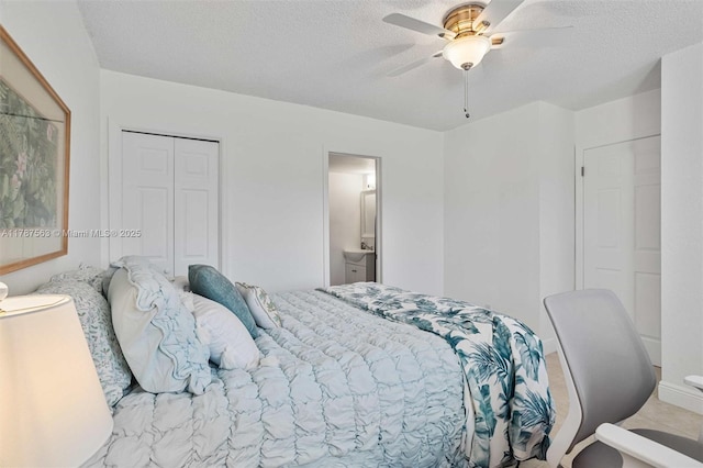 bedroom featuring ensuite bath, a closet, a textured ceiling, and a ceiling fan