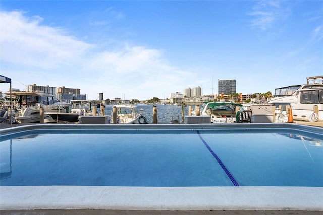 view of swimming pool featuring a city view, a dock, and a water view