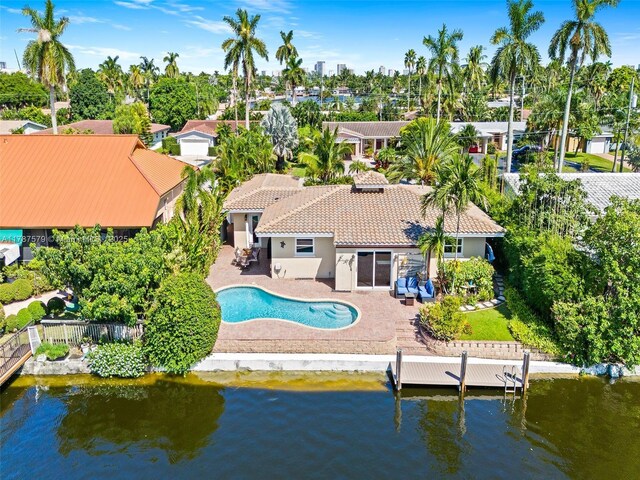 4231 NE 16th Ave, Oakland Park, FL 33334 - back of property featuring a tile roof, a patio area, stucco siding, a fenced backyard, and a water view