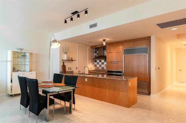 15901 Collins Ave Unit 2502, Sunny Isles Beach, FL 33160 - kitchen featuring wall chimney range hood, paneled built in refrigerator, oven, a peninsula, and visible vents