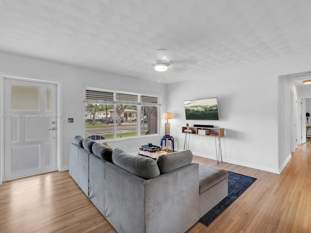 living room with wood finished floors, baseboards, and a ceiling fan
