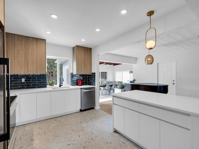 kitchen featuring light countertops, dishwasher, a wealth of natural light, and a sink