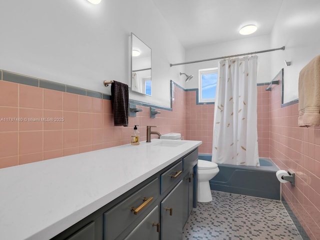 full bathroom featuring a wainscoted wall, shower / bath combination with curtain, toilet, vanity, and tile walls
