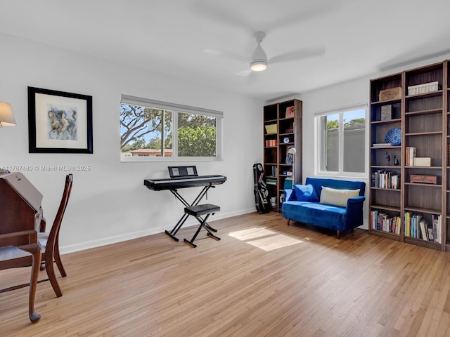 home office with baseboards, a ceiling fan, and light wood-type flooring