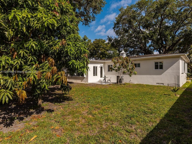 rear view of property with crawl space and a yard