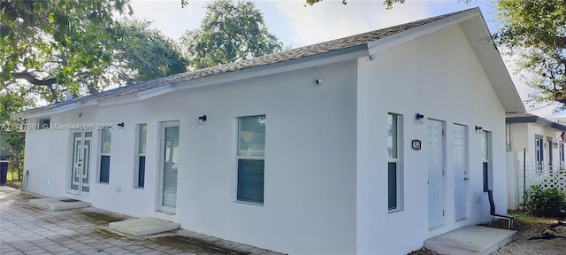 4295 NW 32nd Ave, Miami, FL 33142 - view of side of property featuring french doors, a patio, and stucco siding