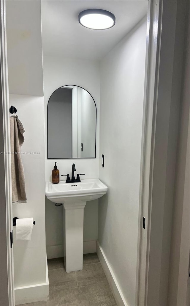 bathroom featuring baseboards and a sink