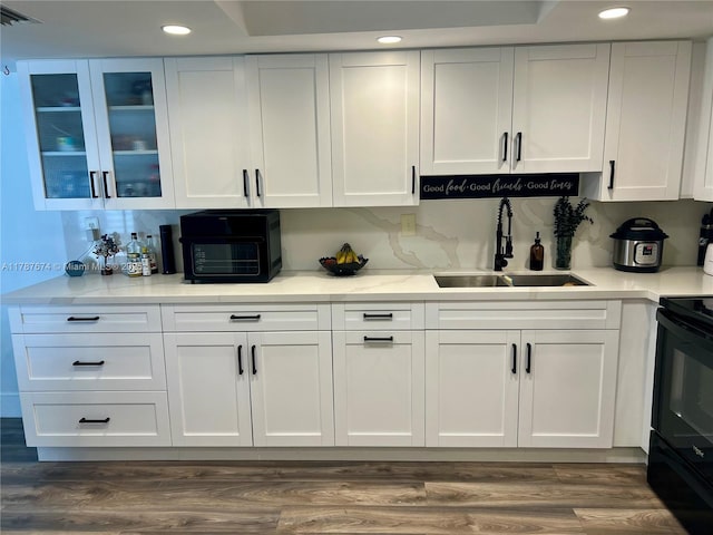kitchen with white cabinets, black / electric stove, recessed lighting, and a sink