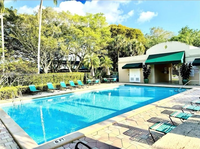 pool with fence and a patio area