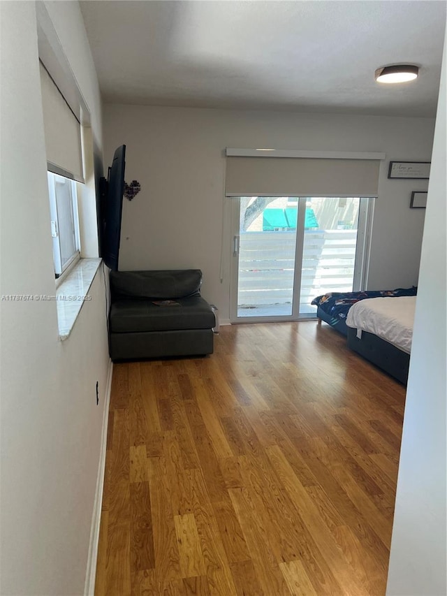 bedroom featuring access to exterior and light wood-type flooring