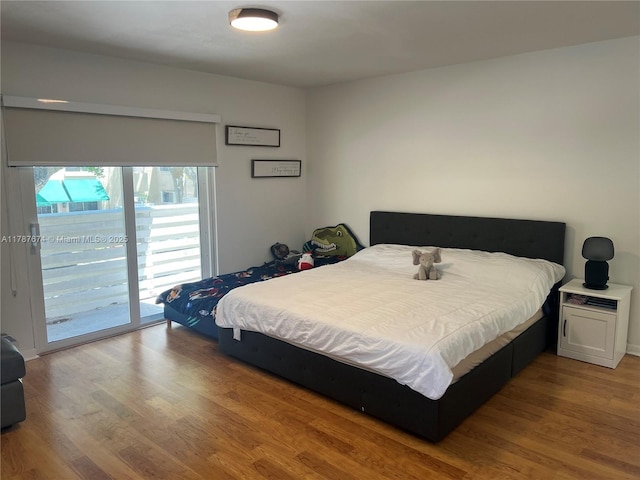 bedroom with wood finished floors and access to outside